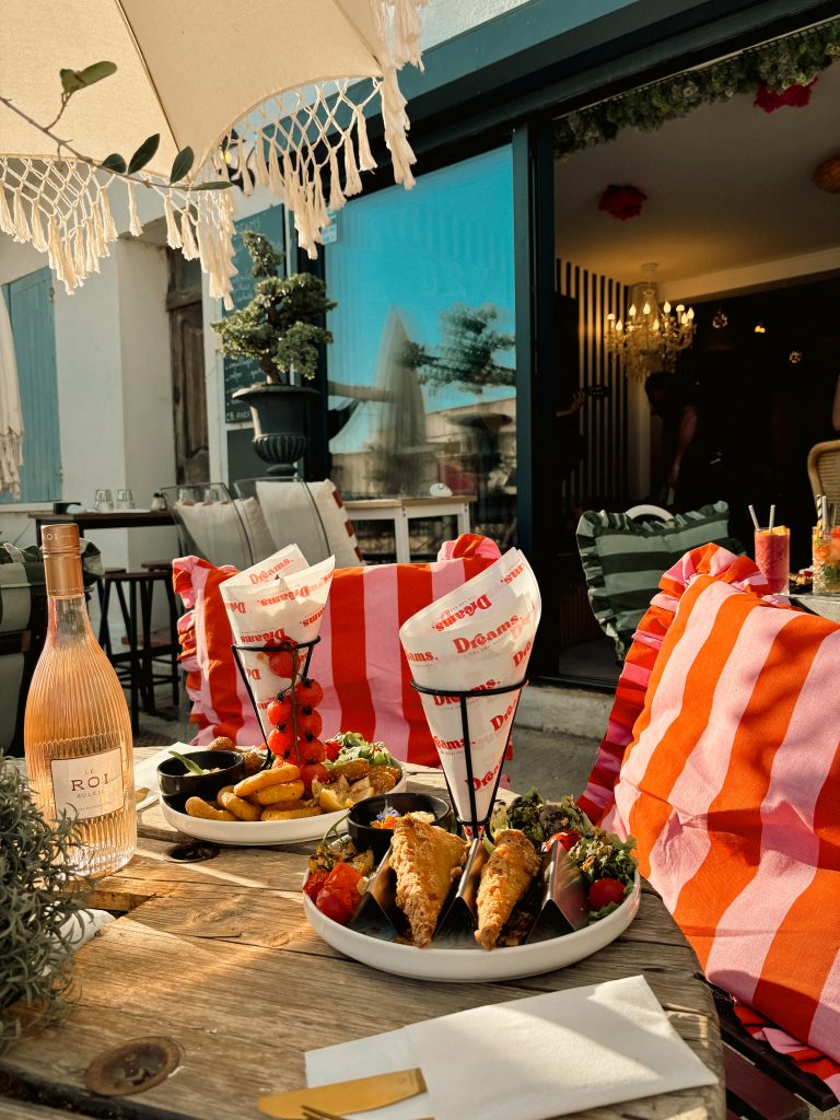 Repas en terrasse à la Brasserie Dreams aux Saintes Maries de la Mer, plats variés et ambiance conviviale.
